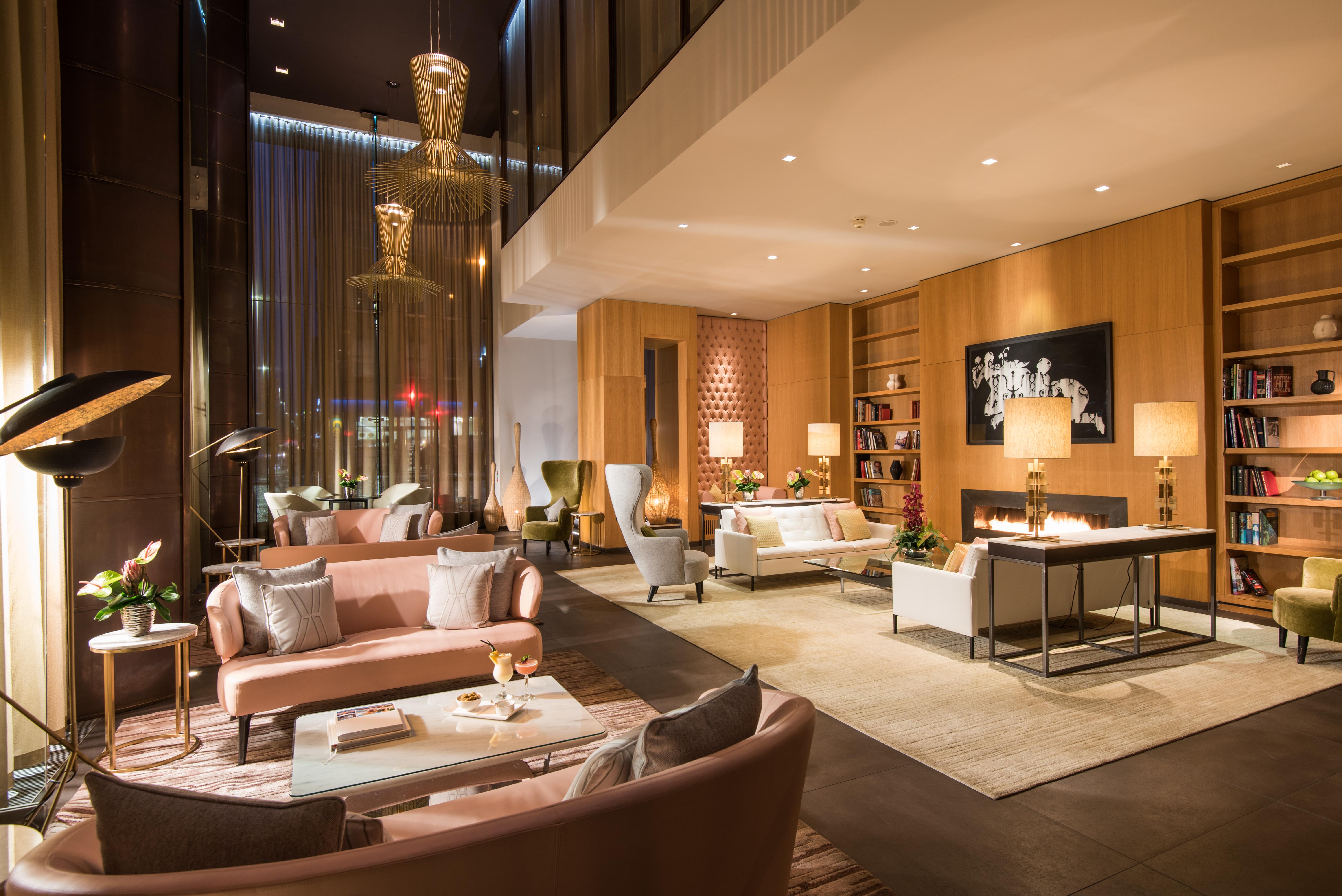 The Fitzwilliam Hotel Belfast Ngoại thất bức ảnh The photo shows a modern and elegant lobby or lounge area. The space features a mix of contemporary and cozy furniture, including light-colored sofas and armchairs arranged around small tables. There are decorative elements like vases with flowers, a